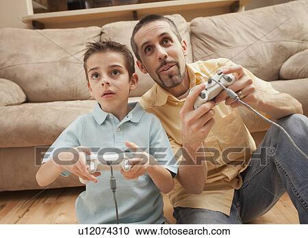 Front view of father and son (8-9) playing Video Games View Large Photo Image Stock Image - Front view of father and son (8-9) playing Video Games. Fotosearch