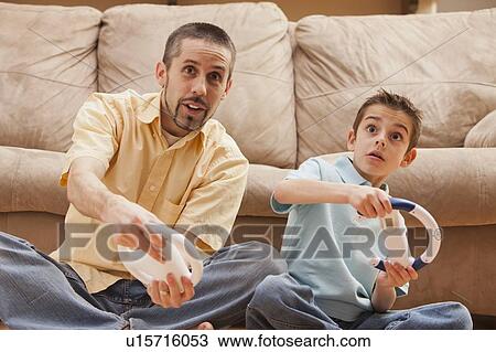 Front view of father and son (8-9) playing Video Games View Large Photo Image Stock Image - Front view of father and son (8-9) playing Video Games. Fotosearch