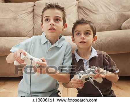 Front view of two boys (6-7, 8-9) playing Video Games View Large Photo Image Stock Image - Front view of two boys (6-7, 8-9) playing Video Games. Fotosearch