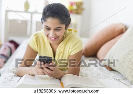 Girl (12-13) lying on bed and texting View Large Photo Image Stock Photography - Girl (12-13) lying on bed and texting. Fotosearch