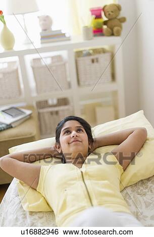 Girl (12-13) lying on bed View Large Photo Image Stock Photograph - Girl (12-13) lying on bed. Fotosearch