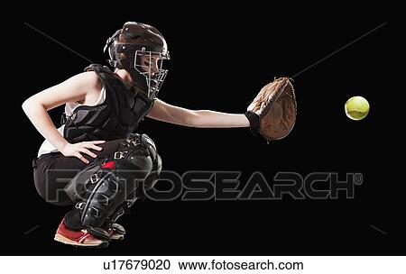 Stock Image - Girl (12-13) plying softball, studio shot. Fotosearch