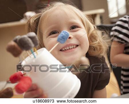 Stock Image - Girl (2-3) showing her craft work. Fotosearch