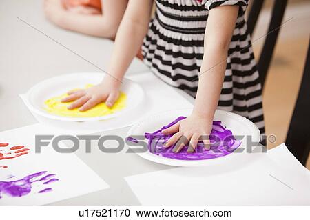 Girl (4-5) holding her hands on plates with paint View Large Photo Image Stock Image - Girl (4-5) holding her hands on plates with paint. Fotosearch
