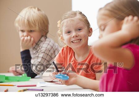Girl (4-5) looking at camera during art lesson in kindergarten View Large Photo Image Stock Photograph - Girl (4-5) looking at camera during art lesson in kindergarten. Fotosearch