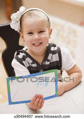 Girl (4-5) showing her drawing View Large Photo Image Stock Photo - Girl (4-5) showing her drawing. Fotosearch