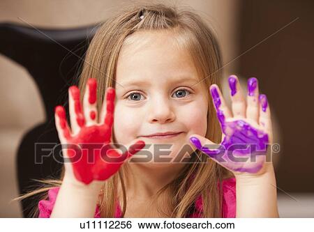 Stock Photograph - Girl (4-5) with paint covered hands. Fotosearch