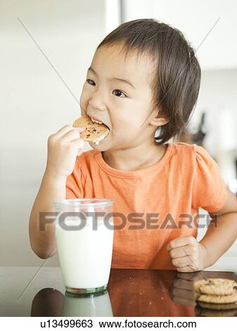 Stock Image - Girl eating cookie (2-3). Fotosearch