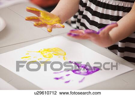 Stock Image - Girl's (4-5) hands printed on paper. Fotosearch