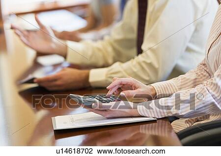 Stock Image - Hands of business people at business meeting. Fotosearch