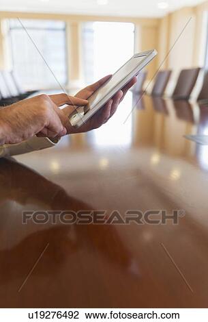 Stock Image - Hands of businessman using tablet pc. Fotosearch