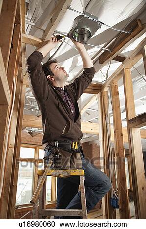 Stock Image - Handyman screwing. Fotosearch
