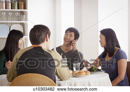 Stock Image - Happy family having meal together. Fotosearch