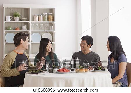Stock Photography - Happy family having meal together. Fotosearch