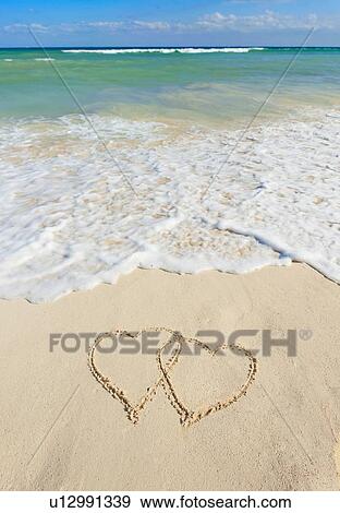 Stock Photo - Heart drawing in sand on beach. Fotosearch