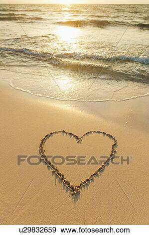 Stock Photo - Heart drawn in sand on beach. Fotosearch