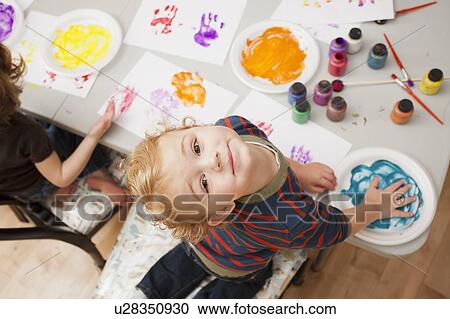Stock Image - High angle view of boy (4-5) making palm print. Fotosearch