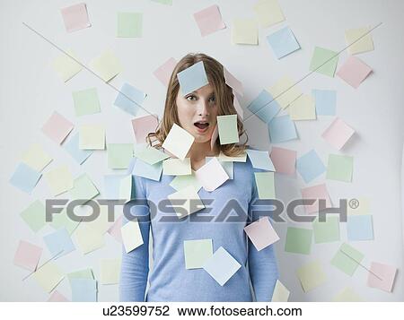 Indoor portrait of young attractive woman standing in f front of wall covered in adhesive notes View Large Photo Image Stock Image - Indoor portrait of young attractive woman standing in f front of wall covered in adhesive notes. Fotosearch