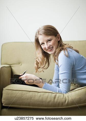 Indoor portrait of young attractive woman reclining on sofa View Large Photo Image Stock Photography - Indoor portrait of young attractive woman reclining on sofa. Fotosearch