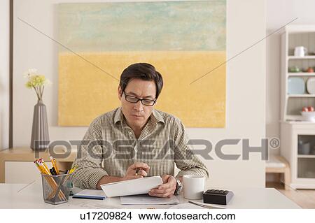 Picture - Man doing paperwork. Fotosearch