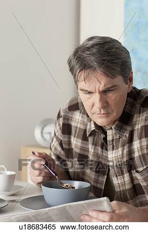 Man eating breakfast and reading newspaper View Large Photo Image Stock Photography - Man eating breakfast and reading newspaper. Fotosearch