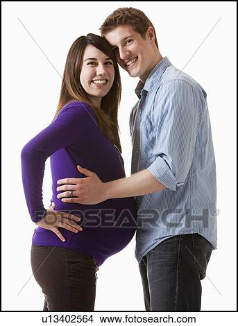 Man embracing pregnant woman, studio shot View Large Photo Image Picture - Man embracing pregnant woman, studio shot. Fotosearch