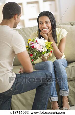 Man giving bouquet of flowers to woman View Large Photo Image Stock Image - Man giving bouquet of flowers to woman. Fotosearch
