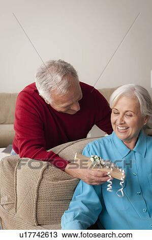 Stock Image - Man giving woman gift. Fotosearch