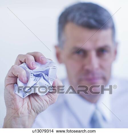 Man holding crumpled paper ball View Large Photo Image Picture - Man holding crumpled paper ball. Fotosearch