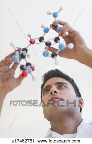 Stock Image - Man holding molecular model. Fotosearch