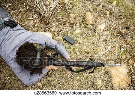 Stock Photo - Man lying on front with weapon. Fotosearch