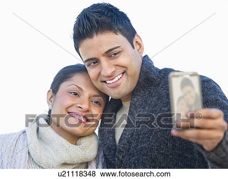 Man photographing himself and girlfriend with mobile phone View Large Photo Image Stock Photo - Man photographing himself and girlfriend with mobile phone. Fotosearch