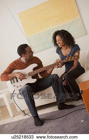 Man playing electric guitar to his girlfriend View Large Photo Image Stock Image - Man playing electric guitar to his girlfriend. Fotosearch