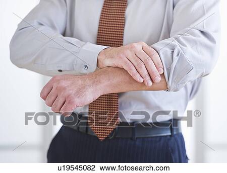 Stock Image - Man rolling up sleeves. Fotosearch