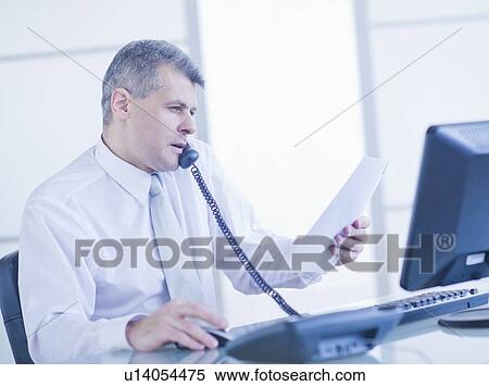Man sitting in office and talking on landline phone View Large Photo Image Stock Photography - Man sitting in office and talking on landline phone. Fotosearch