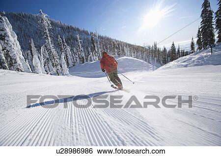 Stock Photograph - Man skiing in mountain scenery. Fotosearch