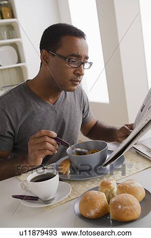 Mature man eating breakfast and reading newspaper View Large Photo Image Stock Image - Mature man eating breakfast and reading newspaper. Fotosearch