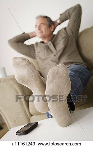 Mature man resting on sofa View Large Photo Image Stock Photo - Mature man resting on sofa. Fotosearch