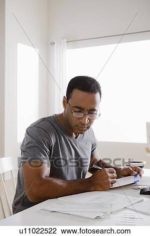 Stock Image - Mature man using calculator. Fotosearch