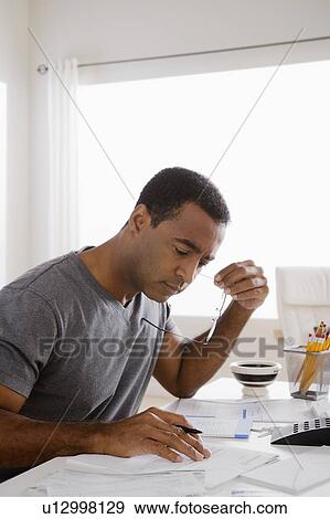 Stock Photo - Mature man using calculator. Fotosearch