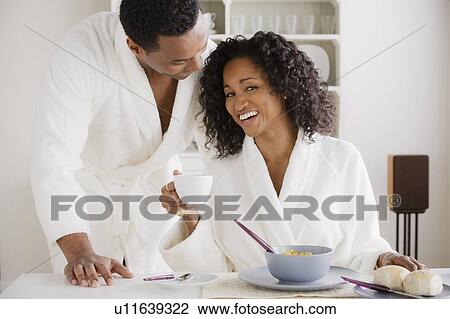 Stock Image - Mid adult couple at breakfast. Fotosearch