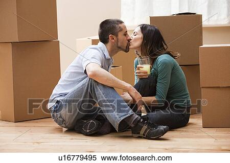 Mid adult couple sitting on floor surrounded by cardboard boxes and kissing View Large Photo Image Stock Photography - Mid adult couple sitting on floor surrounded by cardboard boxes and kissing. Fotosearch