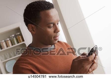 Stock Image - Mid adult man talking via mobile phone. Fotosearch