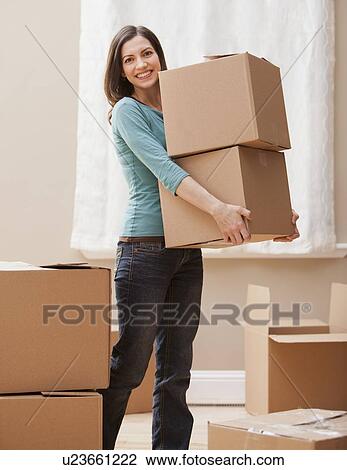 Mid adult woman carrying cardboard boxes View Large Photo Image Stock Image - Mid adult woman carrying cardboard boxes. Fotosearch