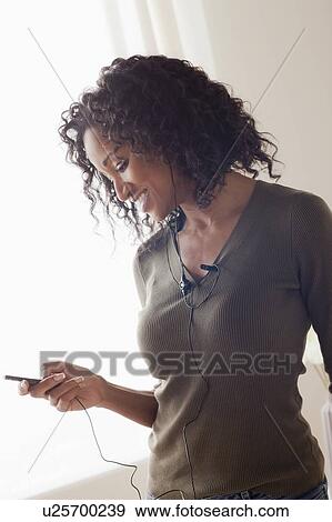 Stock Photo - Mid adult woman listening music. Fotosearch