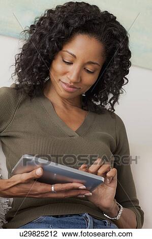 Mid adult woman using digital tablet View Large Photo Image Stock Image - Mid adult woman using digital tablet. Fotosearch