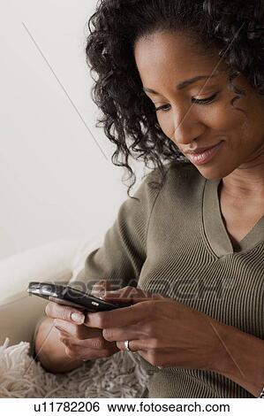 Mid adult woman using mobile phone View Large Photo Image Stock Photograph - Mid adult woman using mobile phone. Fotosearch