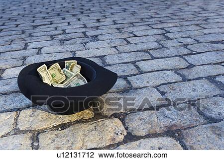 Money in hat on cobblestone street View Large Photo Image Stock Image - Money in hat on cobblestone street. Fotosearch