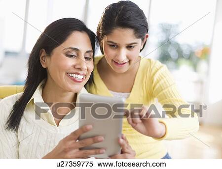 Stock Photography - Mother and daughter (12-13) using digital tablet. Fotosearch