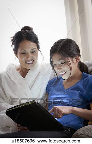 Mother embracing daughter using laptop View Large Photo Image Stock Photograph - Mother embracing daughter using laptop. Fotosearch